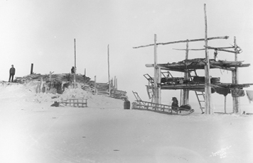 Fig. 1 Storage platform and log/ sod dwelling at Cape Douglas, Alaska.